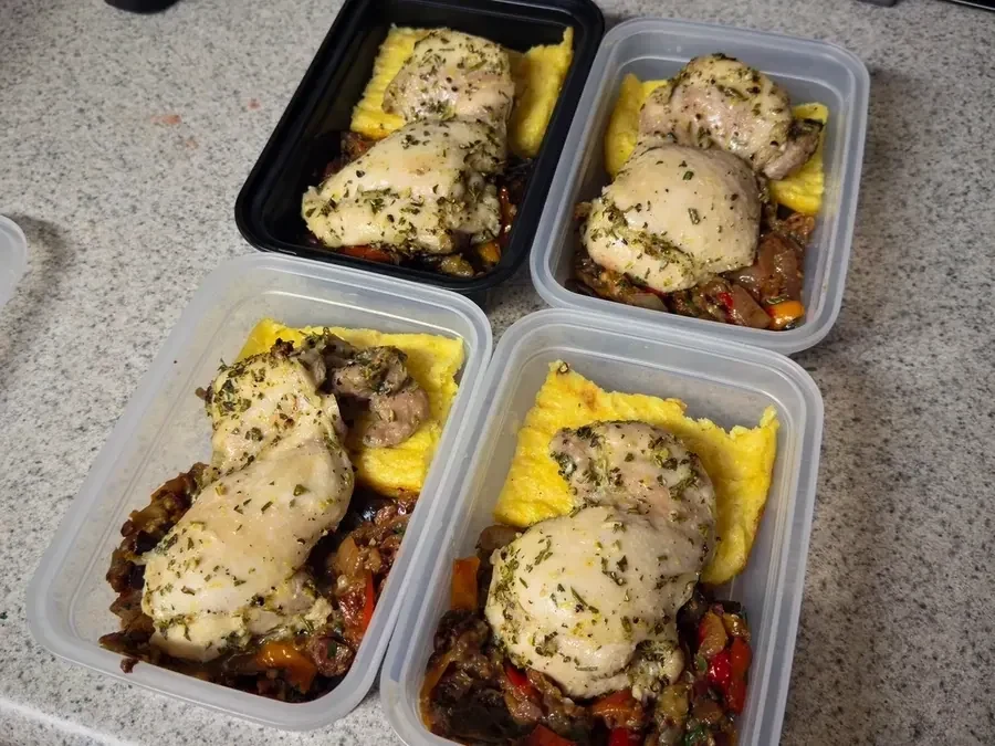 Four meal-prep portions of herb-roasted chicken with creamy polenta and summer vegetables